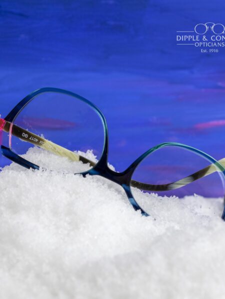 A pair of upside down blue and black glasses in the snow