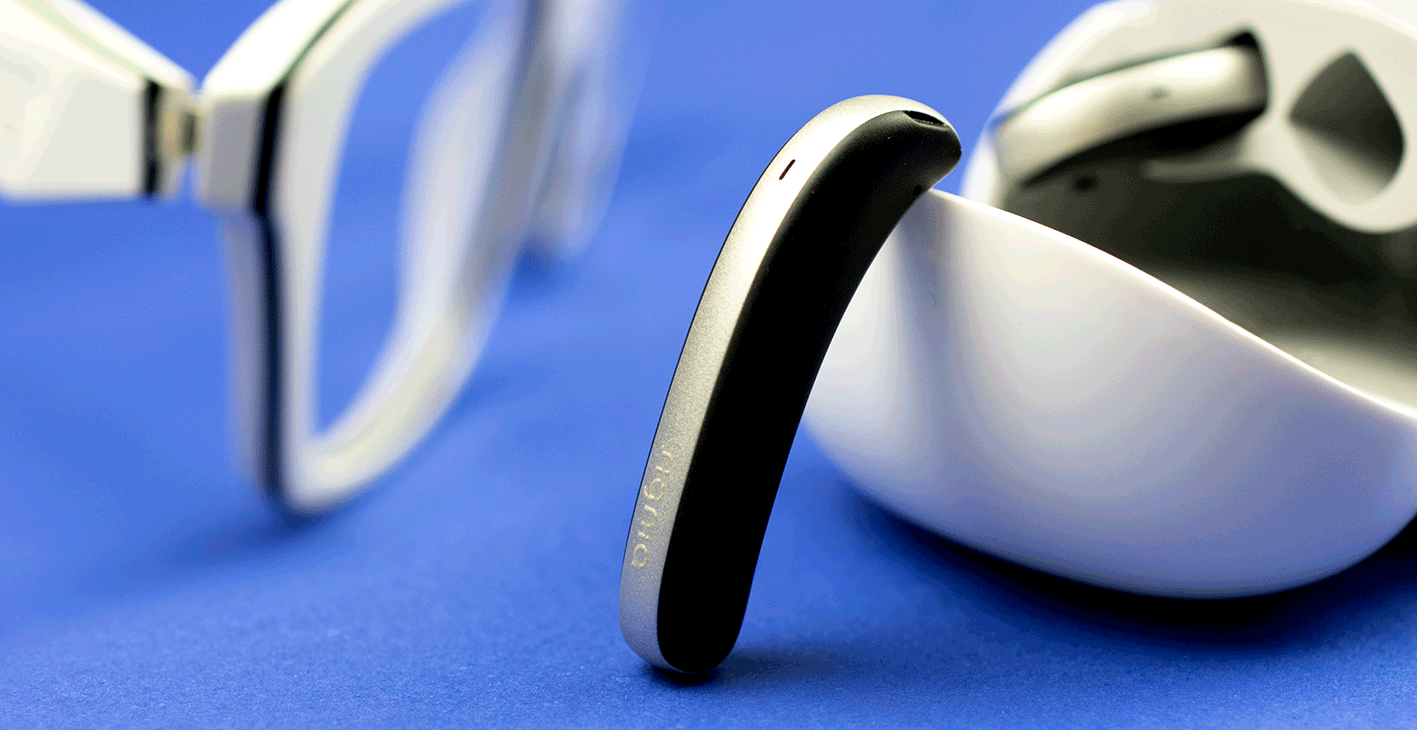 Hearing aids next to glasses frame