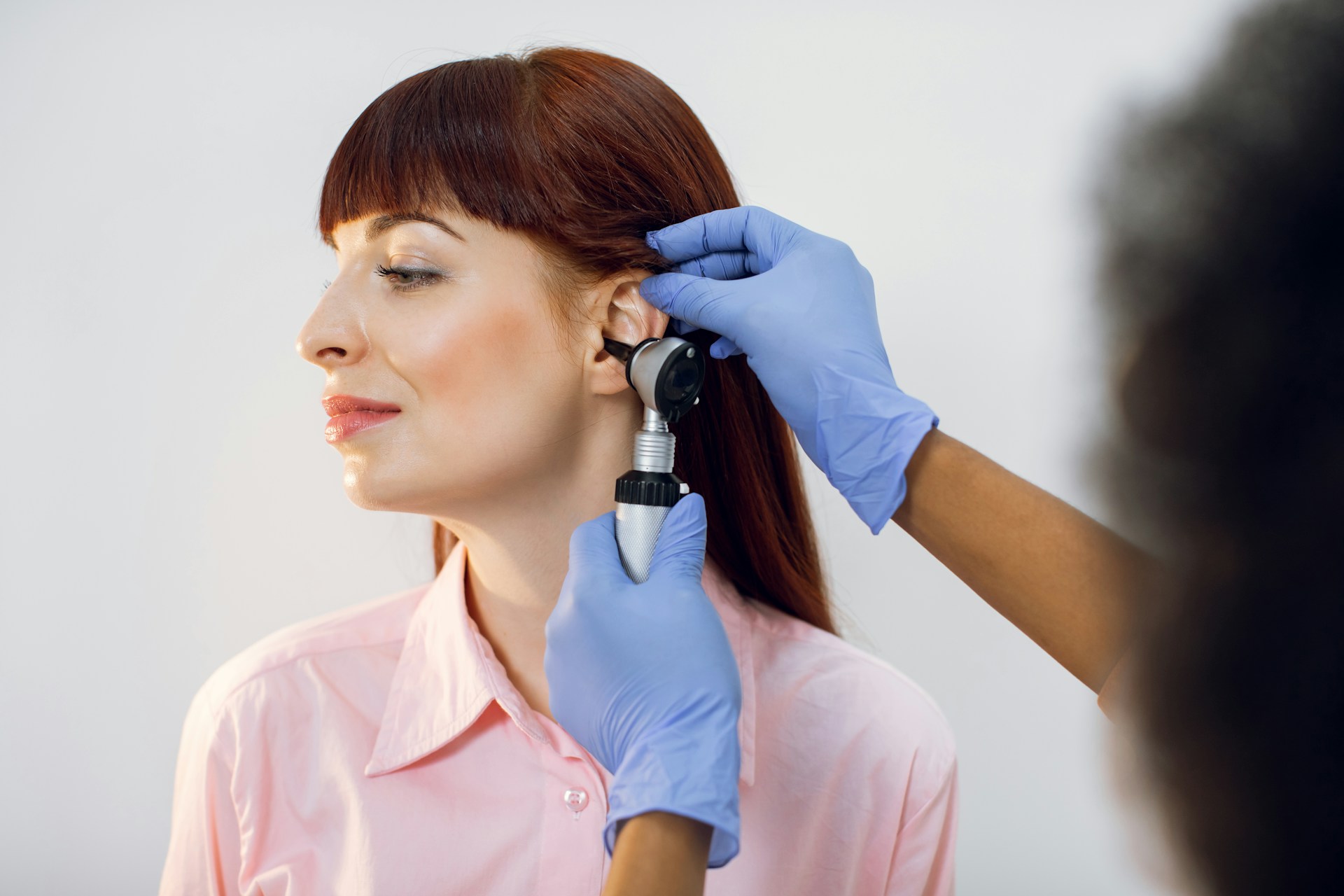 lady giving patient an ear examination